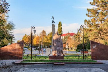 Huzurlu şehir parkı ortamında granit anıt heykel. 13 Ekim 2024 Cimislia Moldova.
