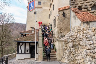 Bir grup insan taş bir merdivenden yukarı çıkıyorlar. 16 Aralık 2024 Bran Romanya.