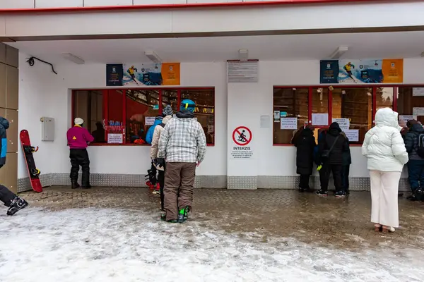 Karlı bir günde kayak merkezinin bilet gişesindeki insanlar. 15 Aralık 2024 'te Romanya.