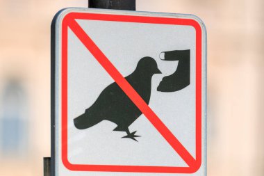 Kırmızı çapraz çizgi yasaklama sembolüyle beslenen güvercinler yok. 19 Mart 2025, Karlovy Vary, Çek Cumhuriyeti.