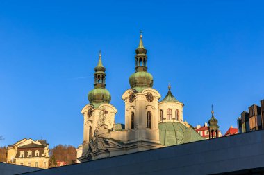 Tarihsel kilise, Avrupa şehir manzarasında açık mavi gökyüzüne karşıdır. 18 Mart 2025, Karlovy Vary, Çek Cumhuriyeti.