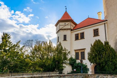 Kırmızı çatılı ve mavi gökyüzüne karşı kulesi olan tarihi Avrupa kalesi. 17 Mart 2025, Konopiste Şatosu, Çek Cumhuriyeti.