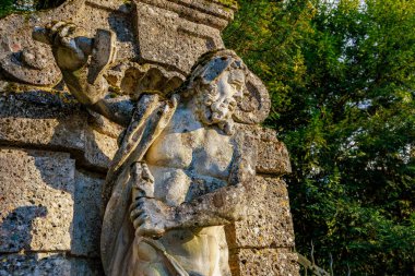 Sakallı savaşçının eski taş heykeli dışarıda büyük bir çekiç tutuyor. 17 Mart 2025, Konopiste Şatosu, Çek Cumhuriyeti.