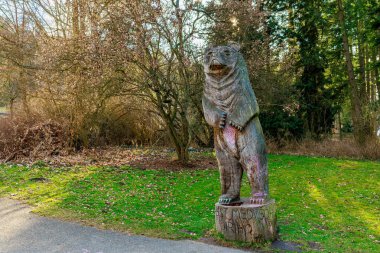Ormandaki park ortamında tahta ayı heykeli. 17 Mart 2025, Konopiste Şatosu, Çek Cumhuriyeti.