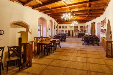 Ahşap tavanı ve klasik avize ışıklandırmasıyla taşralı yemek salonu. 18 Mart 2025, Madalyon, Çek Cumhuriyeti.