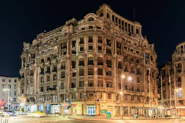 Geceleri muhteşem tarihi bina. Urba 'da ışıklı pencereler ve sokak lambaları var. 8 Mart 2025 Bükreş Romanya.