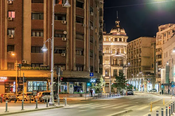 Gece vakti aydınlık binalar ve sakin şehir atmosferiyle tarihi şehir caddesi. 8 Mart 2025 Bükreş Romanya.