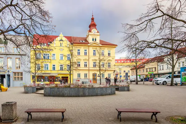 Renkli binaları ve kışın saat kulesi olan tarihi Avrupa şehir meydanı. 17 Mart 2025, Benesov, Çek Cumhuriyeti.
