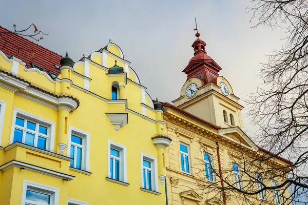 Saat kulesi ve parlak sarı cepheli tarihi Avrupa mimarisi. 17 Mart 2025, Benesov, Çek Cumhuriyeti.