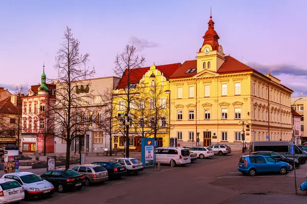 Avrupa 'da tarihi şehir meydanı, saat kulesi ve gün batımında arabalar. 17 Mart 2025, Benesov, Çek Cumhuriyeti.