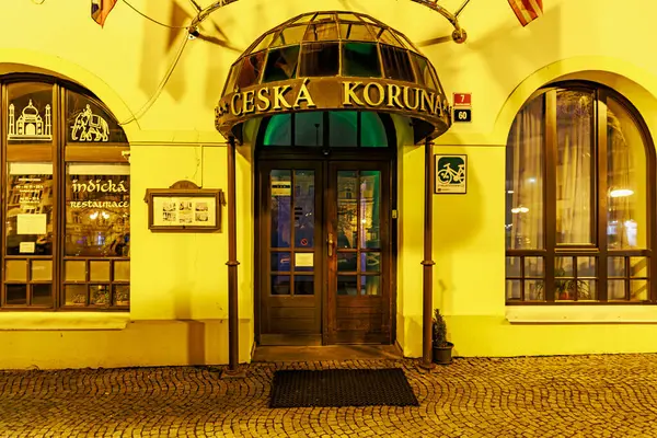 Geceleyin aydınlatma işareti ve cam tepe örtüsüyle tarihi bir Czech restoranı girişi. 16 Mart 2025, Decin, Çek Cumhuriyeti.