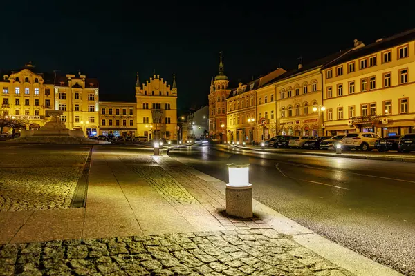 Gece vakti tarihi kasaba meydanının aydınlatılmış binaları ve kaldırımlı caddeleri. 16 Mart 2025, Decin, Çek Cumhuriyeti.