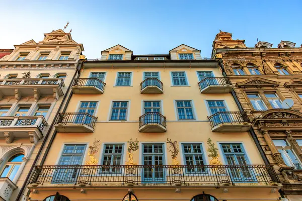 Mavi gökyüzünün altında balkonları ve süslü cepheleri olan tarihi Avrupa mimarisi. 18 Mart 2025, Karlovy Vary, Çek Cumhuriyeti.