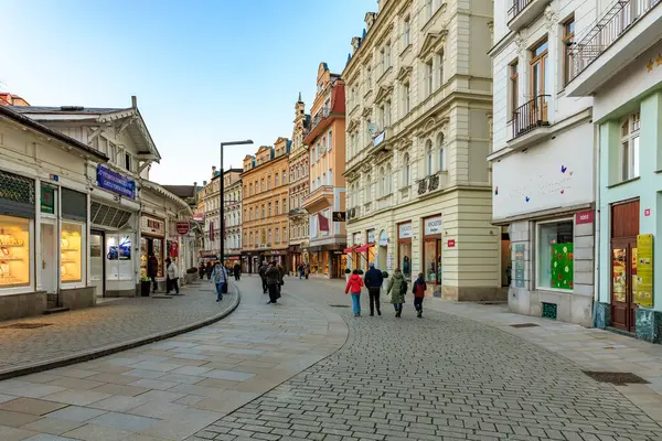 Kültürel sokak sahnesinde tarihi mimari ve gezinen insanlar var. 18 Mart 2025, Karlovy Vary, Çek Cumhuriyeti.