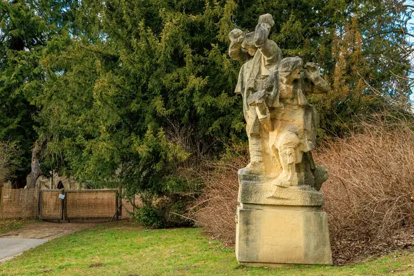 Ağaçlar ve çim manzaralı parkta taş heykel. 17 Mart 2025, Konopiste Şatosu, Çek Cumhuriyeti.