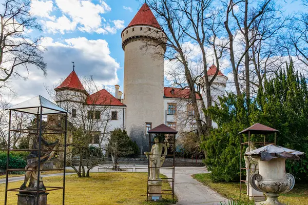 Mavi gökyüzünün altında yapraksız ağaçlarla çevrili tarihi Avrupa kalesi. 17 Mart 2025, Konopiste Şatosu, Çek Cumhuriyeti.