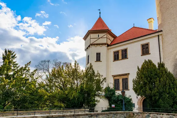 Kırmızı çatılı ve mavi gökyüzüne karşı kulesi olan tarihi Avrupa kalesi. 17 Mart 2025, Konopiste Şatosu, Çek Cumhuriyeti.