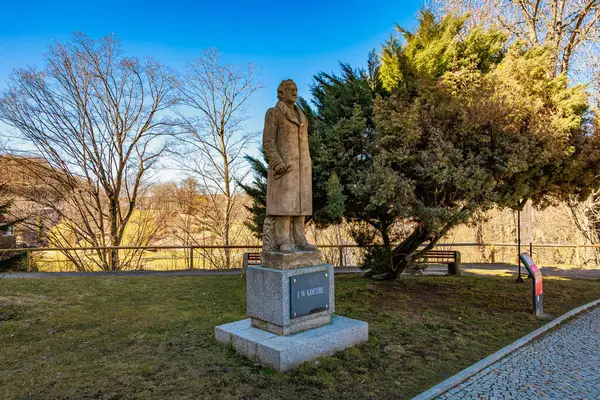 Parkta ağaçlarla süslenmiş kışlık ceketli bir erkek heykeli. 18 Mart 2025, Madalyon, Çek Cumhuriyeti.