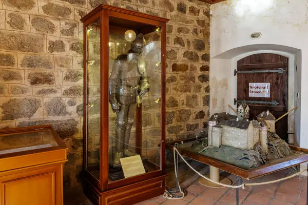 Tarihi taş odada ortaçağ zırhı ve kale modeli. 18 Mart 2025, Madalyon, Çek Cumhuriyeti.