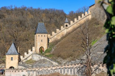 Resimli sonbahar manzarasında kuleleri ve merdivenleri olan ortaçağ şatosu duvarı.