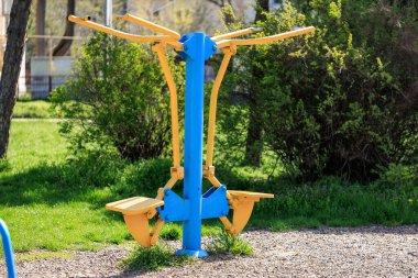 Parktaki sarı ve mavi spor aletleri..