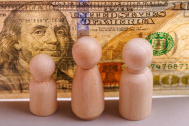 Tahta figürler ve Amerikan para birimi aile finansal planlamasını sembolize ediyor..