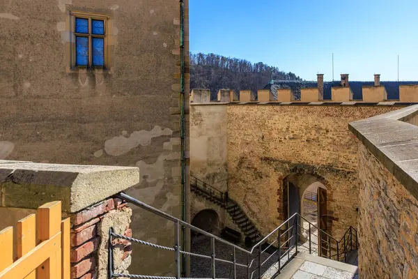 Güneşli bir günde taş merdivenleri ve antik duvarları olan tarihi Avrupa şatosu avlusu.