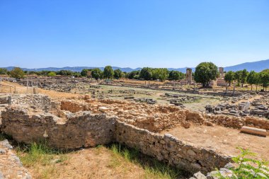 Ortasında duvar olan çorak bir arazi. Duvar taştan yapılmıştır ve etrafında birkaç ağaç büyümektedir. Yunanistan 'ın antik Filippi kentinin kalıntıları