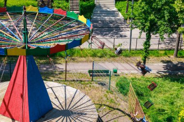 Güneşli parkta yeşil ve patikalı renkli boş bir salıncak..