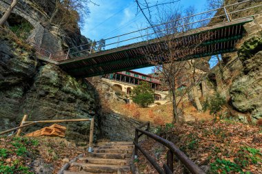 Sonbaharda görkemli kayalık bina ve ahşap köprüye çıkan tarihi taş merdiven..