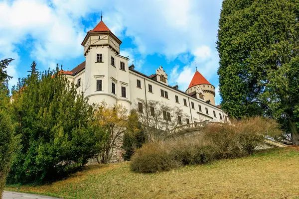 Yeşilliklerle çevrili kırmızı çatı kuleleri olan görkemli ortaçağ kalesi.
