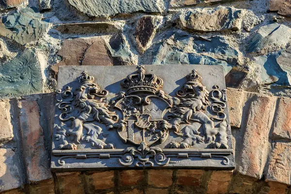 Tuğla duvarda kraliyet arması olan tarihi taş oymacılığı. 4 Mayıs 2025 Romanya.