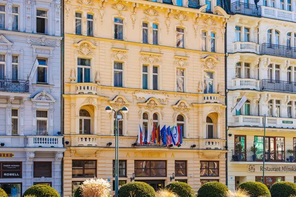 Karlovy 'de bayraklı tarihi astoria oteli cephesi zarif mimari yapılara sahiptir. 19 Mart 2025, Karlovy Vary, Çek Cumhuriyeti.