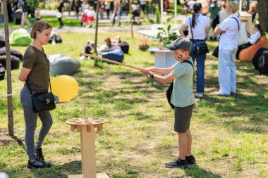 Beyaz bir erkek çocuk, beyaz bir kadınla parkta açık havada oyun oynuyor. 22 Mayıs 2025 Balti Moldova.