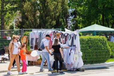 Değişik müşteriler ve geleneksel kıyafet sergisi olan bir açık hava piyasa sahnesi. 22 Mayıs 2025 Balti Moldova.