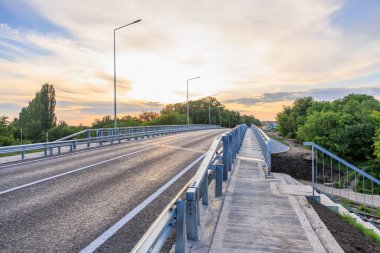 Gün batımında yemyeşil ve açık gökyüzü olan manzaralı otoban köprüsü. 2 Haziran 2025 Balti Moldova.