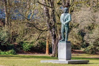 Gündüz vakti yapraklı parktaki bronz heykel. 19 Mart 2025, Karlovy Vary, Çek Cumhuriyeti.