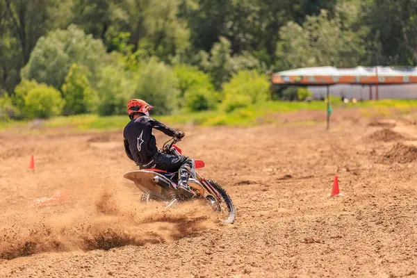 Toprak yolda erkek motokros yarışçısı açık hava yarışında hızlı dönüyor. 31 Mayıs 2025 Vadul lui Voda Moldova.