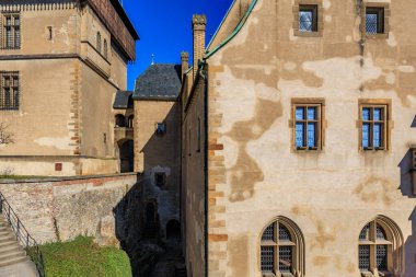 Taş duvarları ve mavi gökyüzü olan tarihi Avrupa kalesi mimarisi.