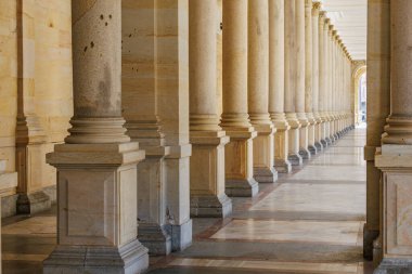 Simetrik mermer tasarımlı büyük mimari taş sütun koridoru.
