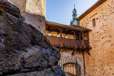Ahşap balkonu ve mavi gökyüzüne karşı kulesi olan tarihi taş bir kale..