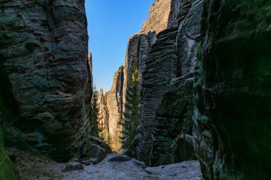 Dar kanyondaki görkemli kumtaşı kayalıkları açık mavi gökyüzünün altında gündüz vakti.