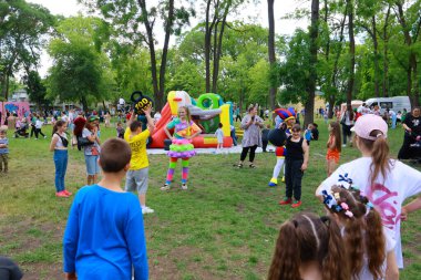 Güneşli bir günde renkli şişme bebeklerle parkta oynayan çocuklar. 31 Mayıs 2024 Balti Moldova.