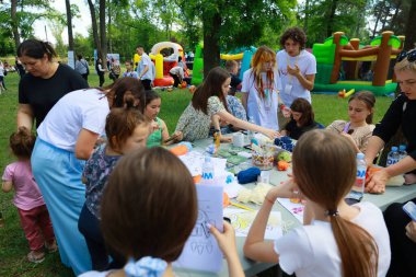 Çocuklar ve yetişkinler parkta el sanatlarıyla uğraşıyorlar. 31 Mayıs 2024 Balti Moldova.