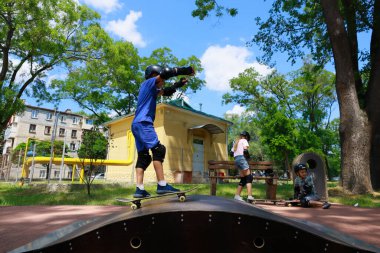 Genç erkek kaykaycı arkadaşlarıyla Sunny Park 'ta gösteri yapıyor. 31 Mayıs 2024 Balti Moldova.
