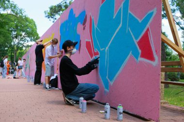 Genç çeşitli sanatçılar açık hava duvarına canlı graffiti yapıyorlar. 31 Mayıs 2024 Balti Moldova.