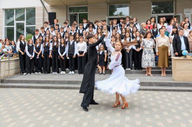 Genç beyaz dansçılar çeşitli izleyicilerle mezuniyet töreninde gösteri yapıyorlar. 2 Eylül 2024 Balti Moldova.