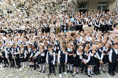 Dışarıda konfeti ile kutlama yapan bir grup üniformalı çocuk. 2 Eylül 2024 Balti Moldova.