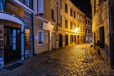 Avrupa 'nın kaldırım taşları ve tarihi binalarıyla büyüleyici bir gece manzarası. 20 Mart 2025, Cesky Krumlov, Çek.