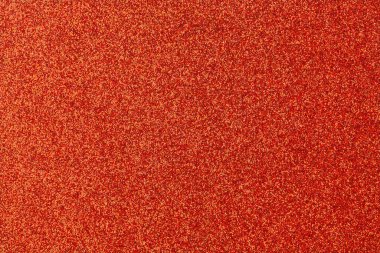 Kırmızı arka planda, etrafa dağılmış birçok turuncu nokta var. Kırmızı arkaplan baskın renktir, turuncu noktalar ise daha küçüktür ve resim boyunca yayılır.